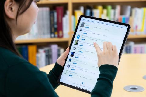 タブレットで蔵書検索をする女性